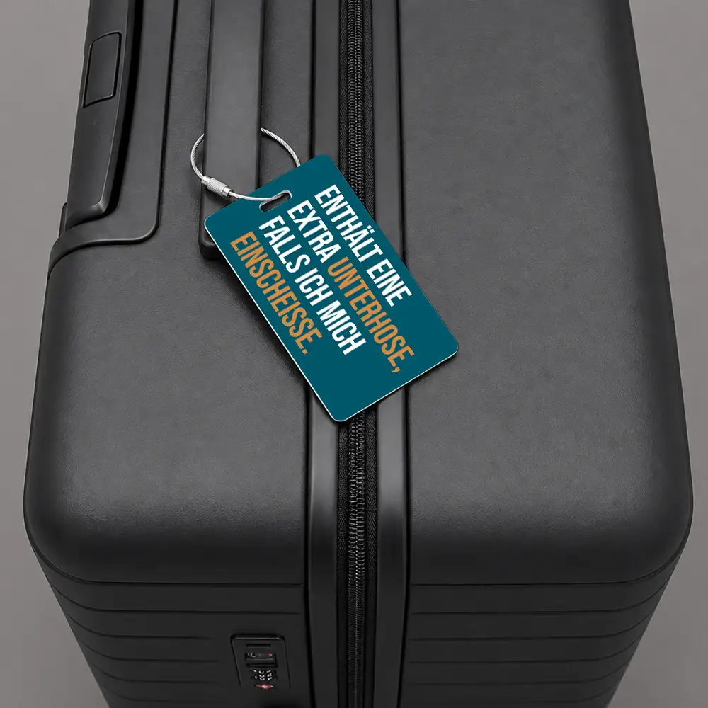 Close-up of a black hard-shell suitcase with a blue luggage tag attached to the zipper pull.