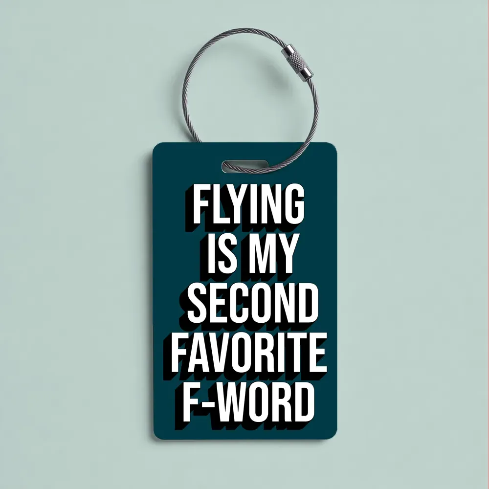 Dark teal luggage tag with bold white text: 'Flying is my second favorite F-word' attached to a metal loop.