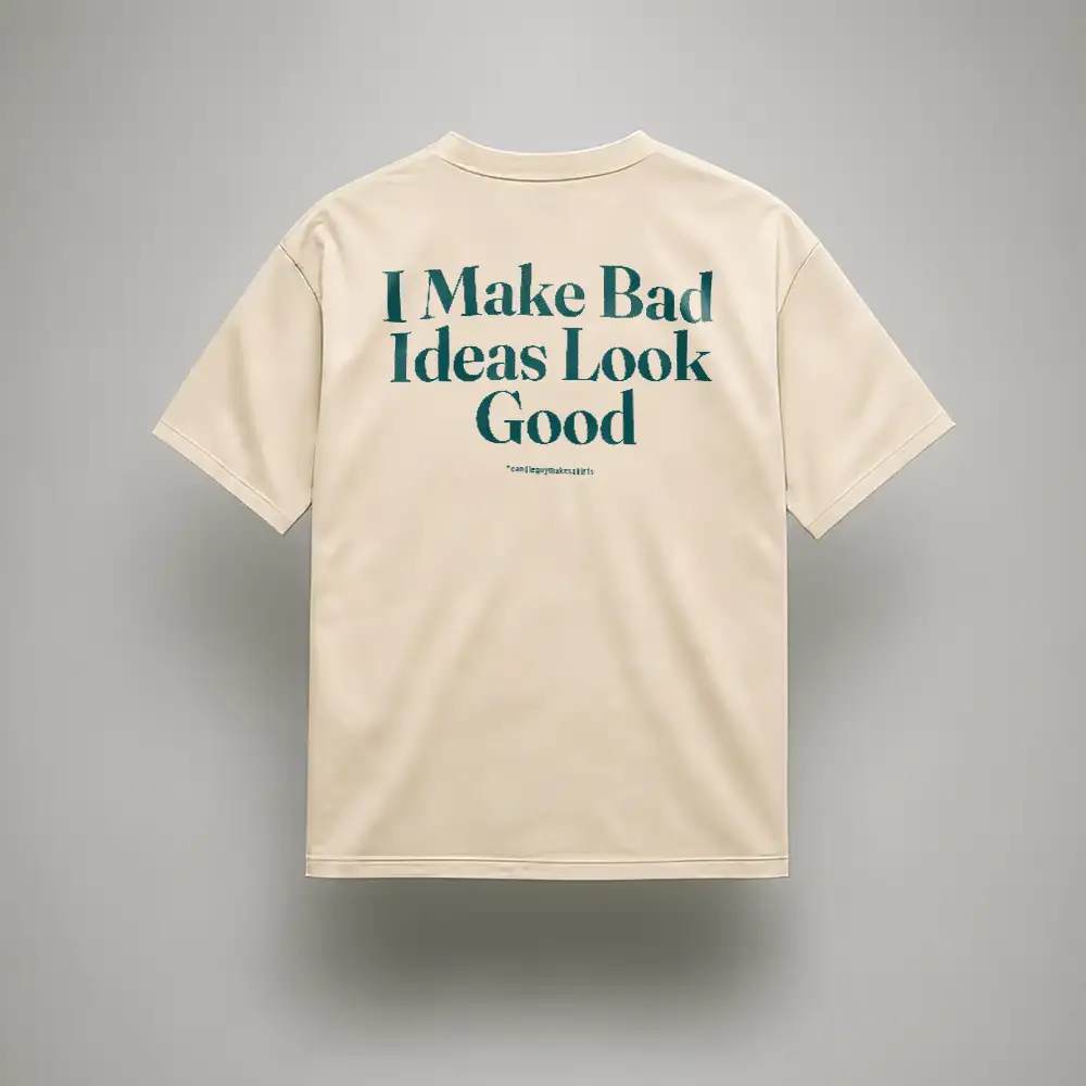 Back view of a beige short-sleeve T-shirt with a large teal slogan: 'I Make Bad Ideas Look Good'.