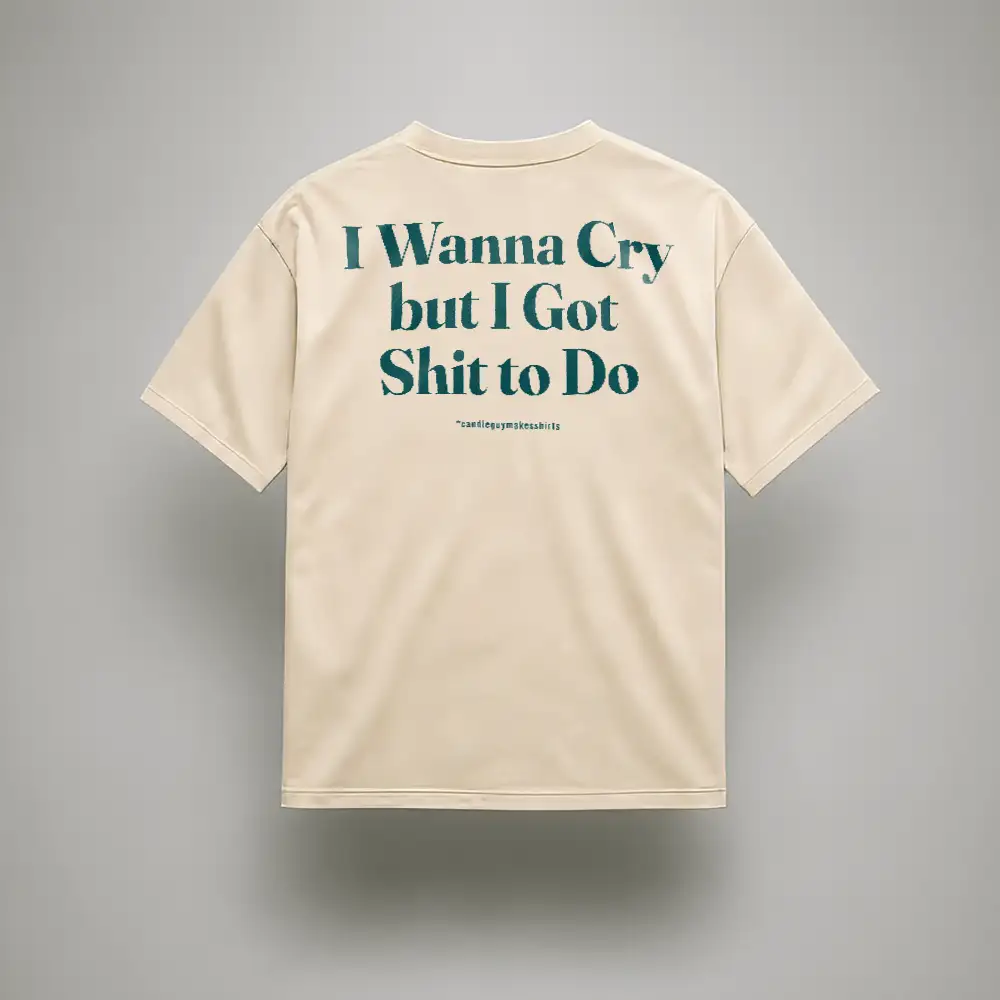 Back view of a beige T-shirt with bold teal text: 'I Wanna Cry but I Got Shit to Do'.