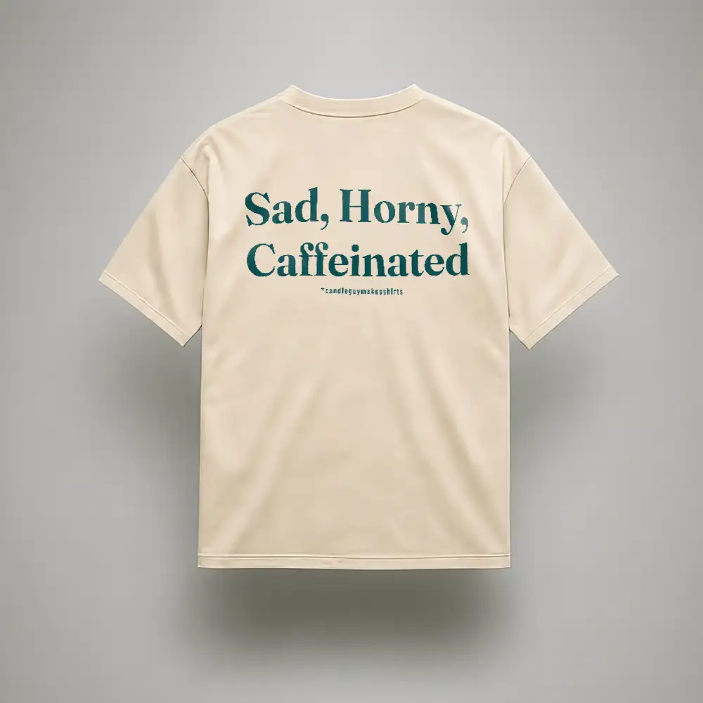 Beige short-sleeve T-shirt with bold teal text on the back: “Sad, Horny, Caffeinated.”