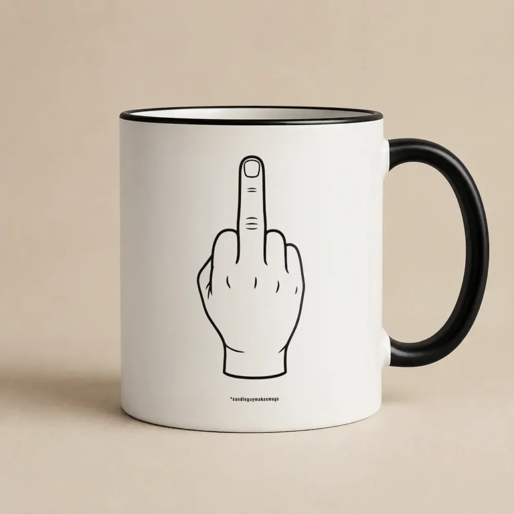 White mug with a black handle and rim, featuring a cartoon hand showing the middle finger.